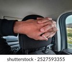 Copilot  adult man with hands intertwined behind copilot car seat