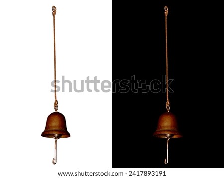A copper bell on a string on isolated white and black background