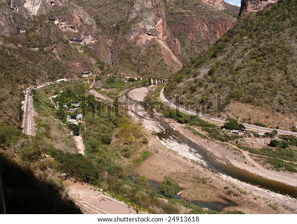 Copper Canyon railway winds its way into the\
interior of Mexico over a curving bridge  seen here from the third\
of three levels of train\
track
