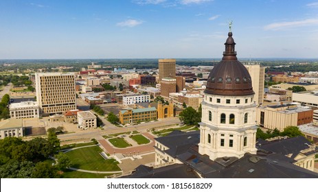 The copper dome shines in the urban area at the capitol building of Topeka Kansas