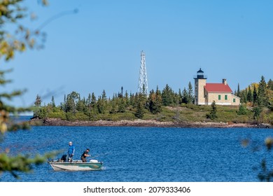 Copper Harbor Lighthouse on Lake Superior, with defocused fishermen in a boat