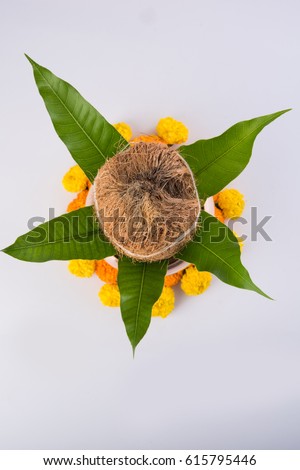 copper kalash with coconut and mango leaf with floral decoration. essential in hindu puja, selective focus, over white background