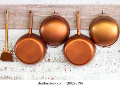 Copper  kitchen utensil on the white painted brick wall