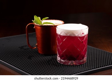 Copper Mug Of Moscow Mule Drink And Berry Drink With Mint Leaves Seen From The Front On The Bar Counter