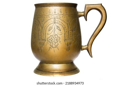 Copper Mug With A Pattern On A White Background. Antique Metal Brass Utensils. Museum Exhibit Item Of Utensils Of Kings.