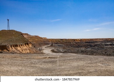 Copper Ore Open-pit Mining. Quarry Panorama. Electric Mast And Quarry Machine On Blue Sky Background.