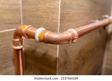 Copper Pipe Elbow For For Natural Gas Installations, Attached To A Wall In A Boiler Room Lined With Ceramic Tiles.