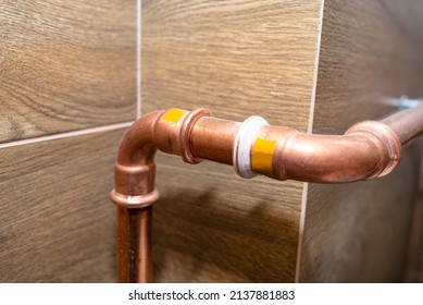 Copper Pipe Elbow For For Natural Gas Installations, Attached To A Wall In A Boiler Room Lined With Ceramic Tiles.