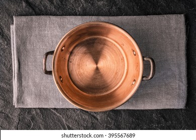 Copper pot on the dark stone table top view
