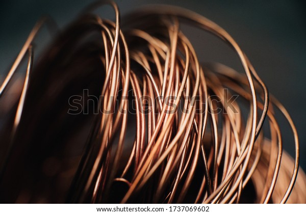 Copper scrap metal, wire, windings of\
motors and transformers, electrical wire without insulation.\
Against the background of a copper sheet. Close-up.\
Macro.