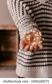 Copper string light in woman hands. Christmas mood and atmosphere. Blurred photos, bokeh.
