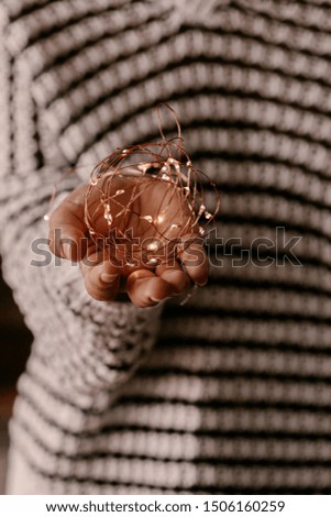 Copper string light in woman hands. Christmas mood and atmosphere. Blurred photos, bokeh.