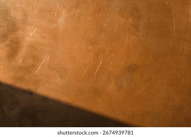 Copper surface in sunlight, with deep shadow in the lower left corner. Background for design and text.