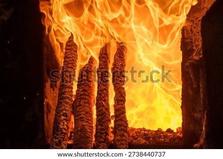 Copper toughening process in closeup view. Wood log in the gas furnace. Flame and sparks on the background.