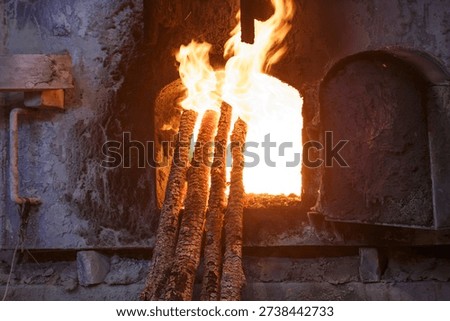 Copper toughening process in closeup view. Wood log in the gas furnace. Flame and sparks on the background.