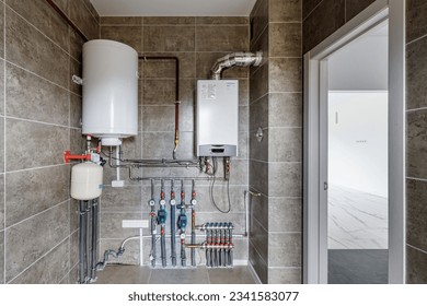 Copper valves, stainless ball valves, detectors of water pressure and plastic pipes of central heating system and water pipes with thermal insulation in the boiler room in apartment during under.