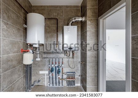Copper valves, stainless ball valves, detectors of water pressure and plastic pipes of central heating system and water pipes with thermal insulation in the boiler room in apartment during under.