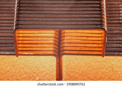 Coppered staples photographed close-up in brown tones. Three groups of copper staples arranged in a pyramid shape