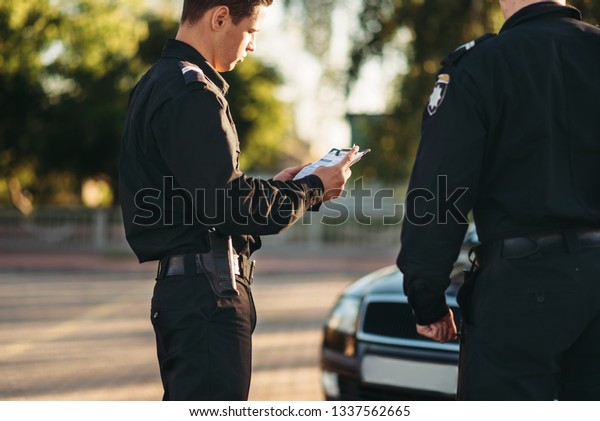 Cops in uniform stop the\
car on road
