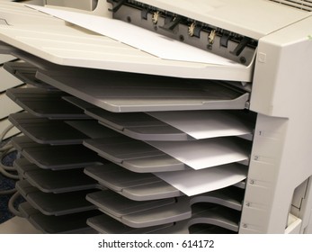 A Copy Machine With Copies In Tray