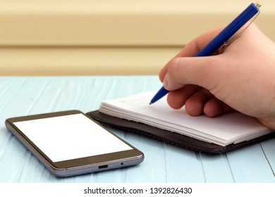 copy spaсe, man taking notes in a notebook from a phone