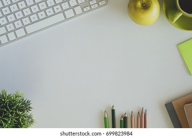 Copy space with keyboard, coffee cup, apple, pencil, book and brush of tree on white background with green color tone, Mock up, Top view.
