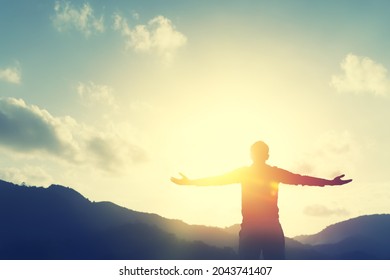 Copy space of man hand raising on top of mountain and sunset sky abstract background. Freedom travel adventure and business victory concept. Vintage tone filter effect color style. - Powered by Shutterstock