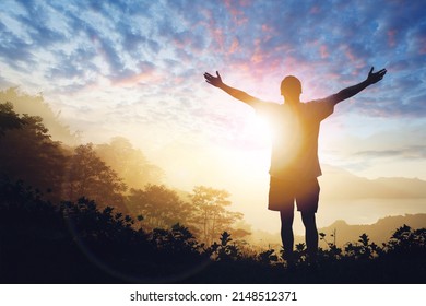 Copy space of man raise hand up on sunset sky - Shutterstock ID 2148512371