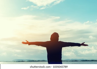 Copy space of man rise hand up on sunset sky at beach and island background. Freedom and travel adventure concept. Vintage tone filter effect color style. - Shutterstock ID 1035043789