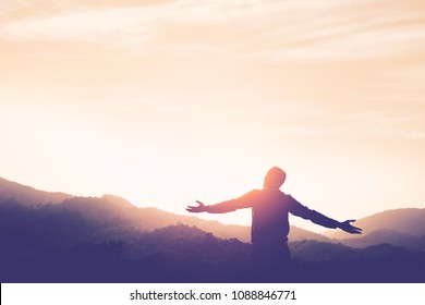 Copy space of man rise hand up on top of mountain and sunset sky abstract background. Freedom and travel adventure concept. Vintage tone filter effect color style. - Shutterstock ID 1088846771