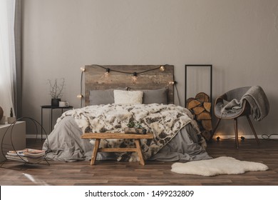 Copy space on empty grey wall of stylish bedroom interior with wooden accents and king size bed - Powered by Shutterstock