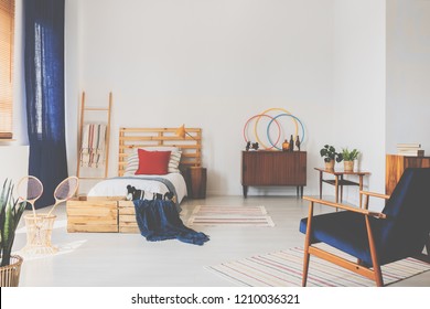 Copy Space On The White Wall Of Oldschool Teenager Bedroom With Wooden Furniture And Dark Blue Accents