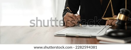 copy space, panorama, banner asian female consultant or lawyer sitting with scale and pointing with pen at signing document to read and check details of recorded data. recorded data justice concept.