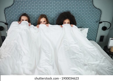 Copy Space Photo Of Three Attractive Young Women Lying In Bed And Pulling White Blanket Up To Their Eyes