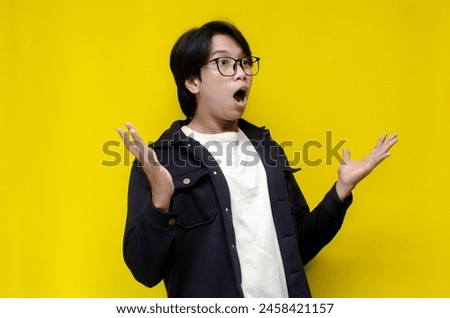 copy space side view of estactic attractive young asian man shocked happily opening mouth and lowering glasses. asian man with glasses feels shock with wow surprised expression