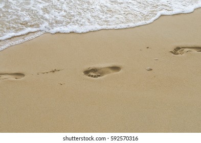 Copy space of smooth wave and footprint on sand beach texture background. Summer vacation and business travel freedom adventure concept. Vintage tone filter effect color style.