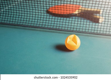 Copy Space And Soft Focus At Broken Ping Pong Ball On The Table Tennis / Soft Light Background With The Net And Ping Pong Paddle / Concept Of Encouragement, Competition And Never Give Up 