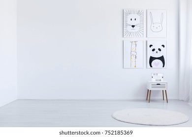 Copy Space Of White Spacious Autistic Kid's Room With Drawings, White Cabinet And Carpet