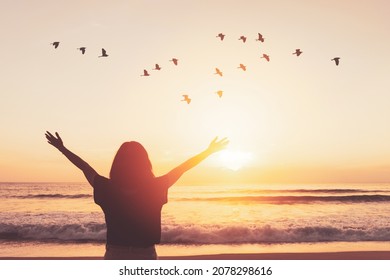 Copy space of woman raise hand up on sunset sky at beach and island with birds flying abstract background. Freedom and travel adventure concept. Vintage tone filter color style. - Shutterstock ID 2078298616