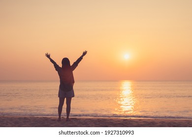 Copy space of woman rise hand up on sunset sky at beach and island background. Freedom and travel adventure concept. Vintage tone filter effect color style.