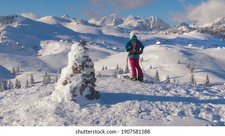 COPY SPACE: Young Female Splitboarder Observes The Picturesque Winter Scenery After Reaching The Scenic Mountaintop. Picturesque Snowy Landscape Surrounds Woman Ski Touring In Slovenian Mountains.