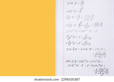 Copybook with maths formulas on yellow background