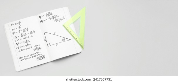Copybook with maths formulas and ruler on grey background with space for text