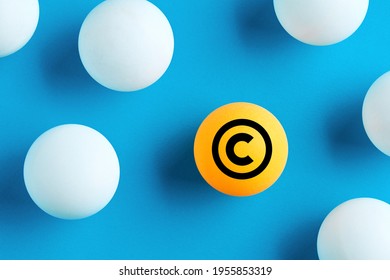Copyright icon on yellow ball on blue background. Property and intellectual rights protection.