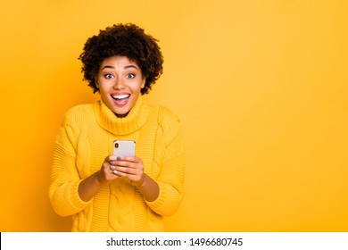 Copyspace photo of cheerful nice cute charming curly girlfriend black skinned wearing yellow pullover with collar holding phone in her hands while isolated with bright color background - Shutterstock ID 1496680745