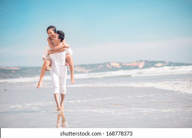 Copy-spaced image of a cheerful young couple piggybacking on the beach 