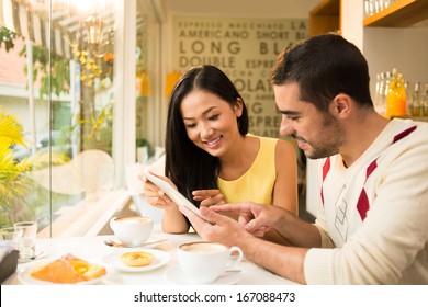 Copy-spaced image of a young couple networking while having breakfast at a cafe  - Powered by Shutterstock