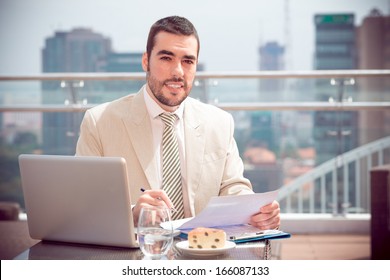  Copy-spaced portrait of a young handsome businessman working while his lunch at a cafe 