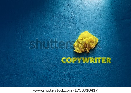 Copywriter propagation concept. Yellow crumpled paper (symbol of unsuccessful text without idea) and text copywriter on blue background.