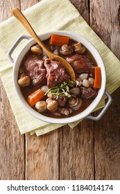 Coq Au Vin - French Food Slowly Cooked Cock With Wine And Vegetables Close-up In A Pot On The Table. Vertical Top View From Above
